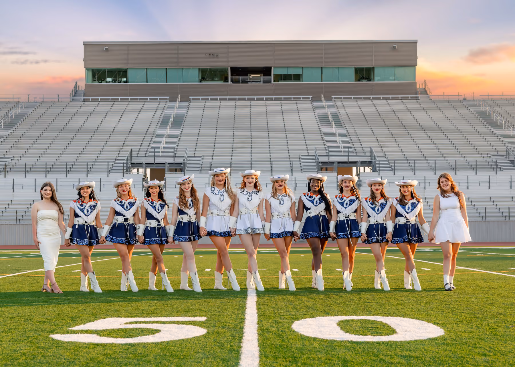 The kick line linked together at sunset